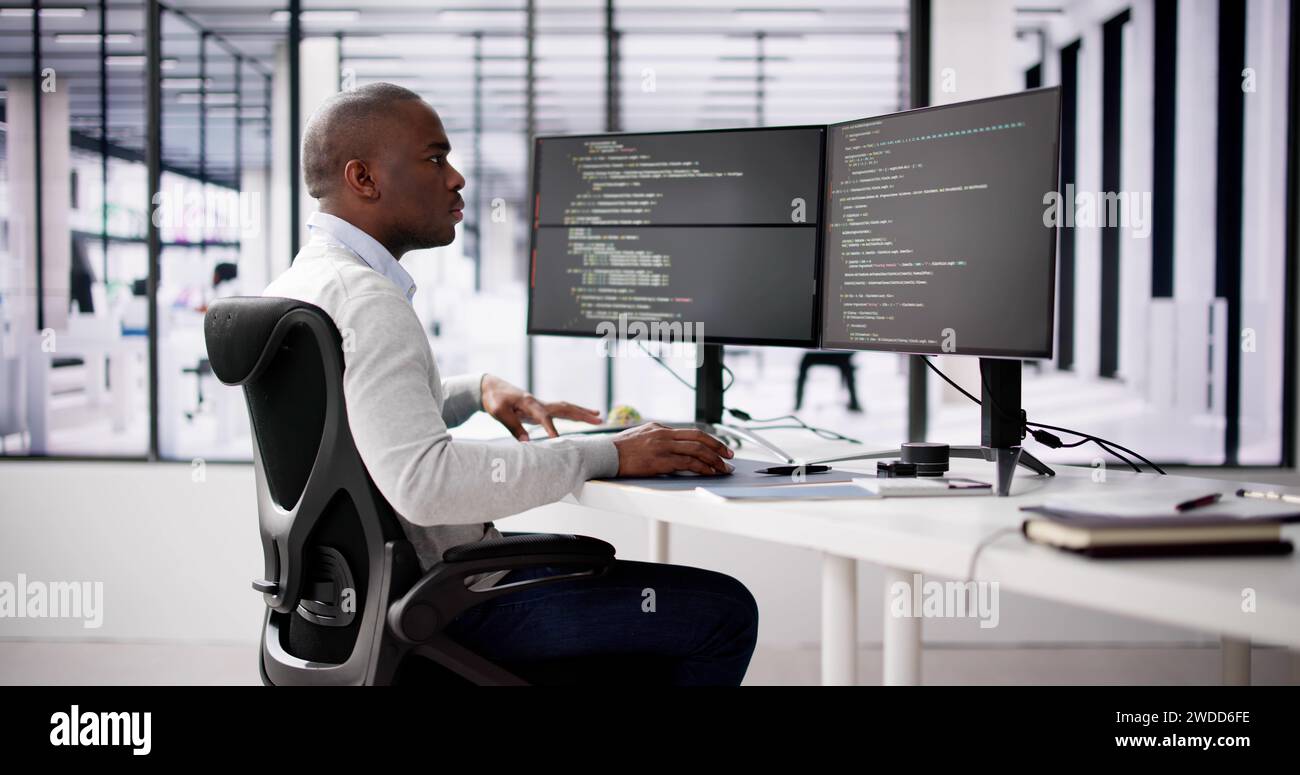 African American Coder Using Computer At Desk. Web Developer Stock Photo