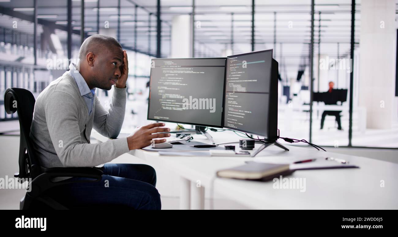Unhappy Sad Developer Programmer Man In Stress Coding Software On Computer Stock Photo