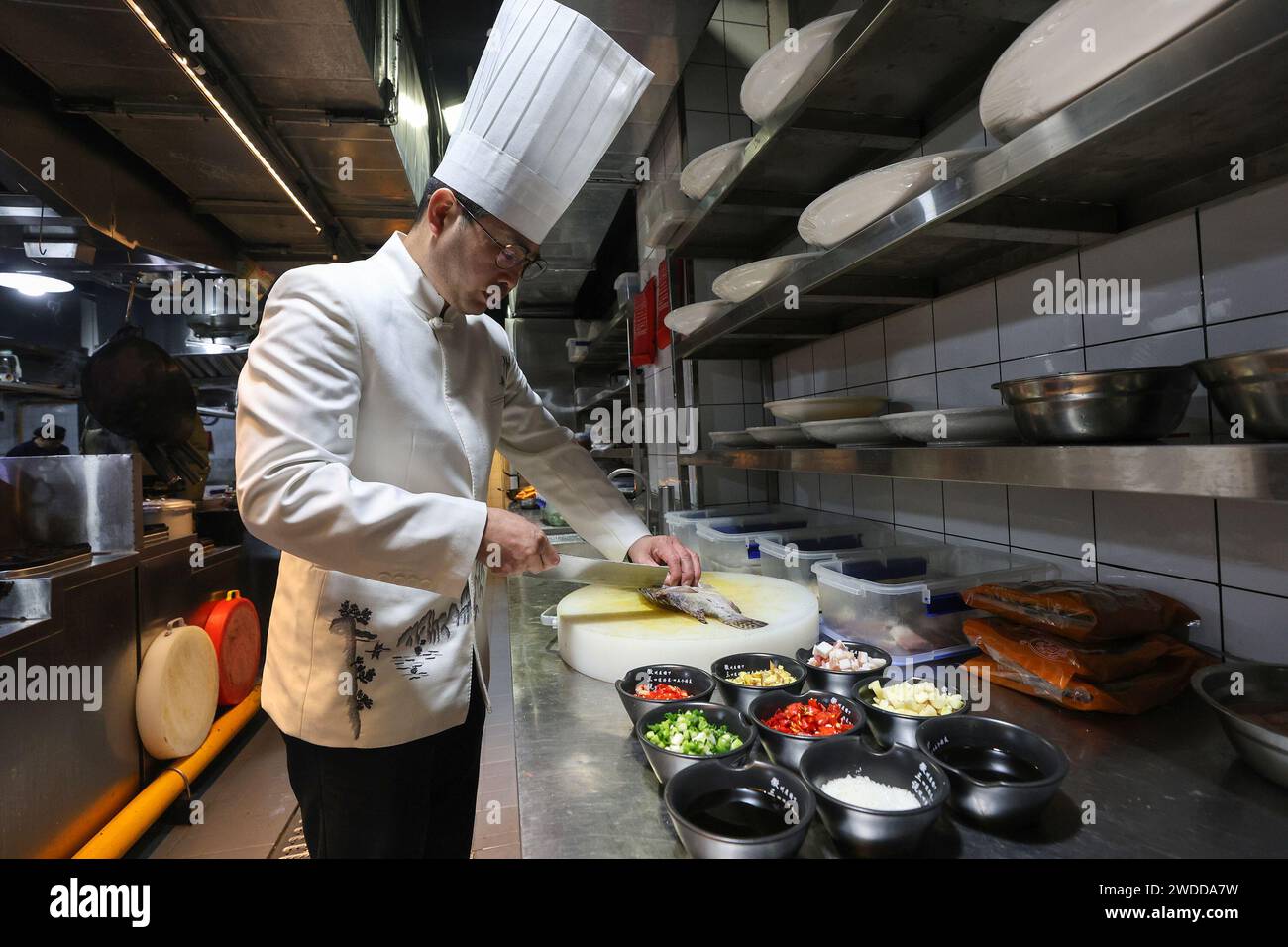 (240120) -- HUANGSHAN, Jan. 20, 2024 (Xinhua) -- A chef prepares to cook fermented mandarin fish at a restaurant in Huangshan City, east China's Anhui Province, Jan. 11, 2024. The fermented mandarin fish, also known as 'Chouguiyu,' is a representative of Anhui cuisine, which originated in the historical Huizhou region. Its unique smell and delicious taste have gained praise from gourmets. In recent years, Huangshan City in east China's Anhui Province has vigorously promoted the development of fermented mandarin fish industry. Various initiatives have been implemented, including the formulati Stock Photo