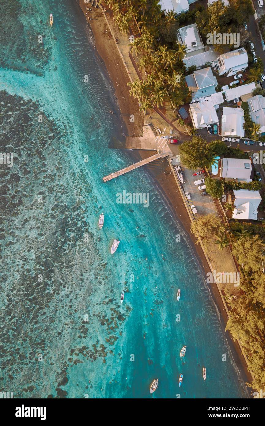 An aerial view of a marina with its boats and jetty, in a tropical lagoon. The water is turquoise blue, transparent. Etang-Salé, Reunion Island. Stock Photo
