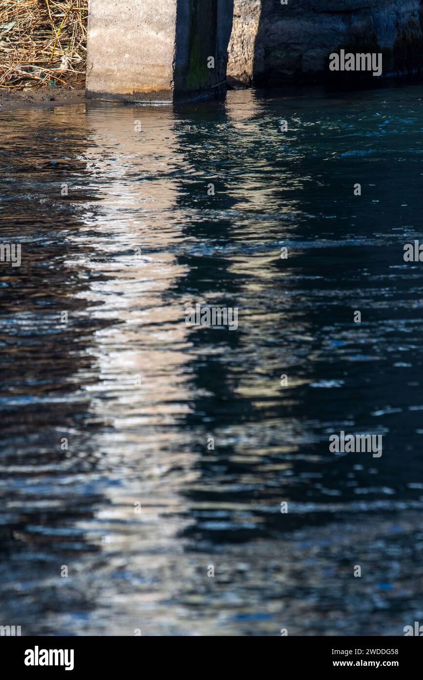 Reflection in the water. Concrete pillar. Abstract art. River Bregalnica, Macedonia 2024 Stock Photo
