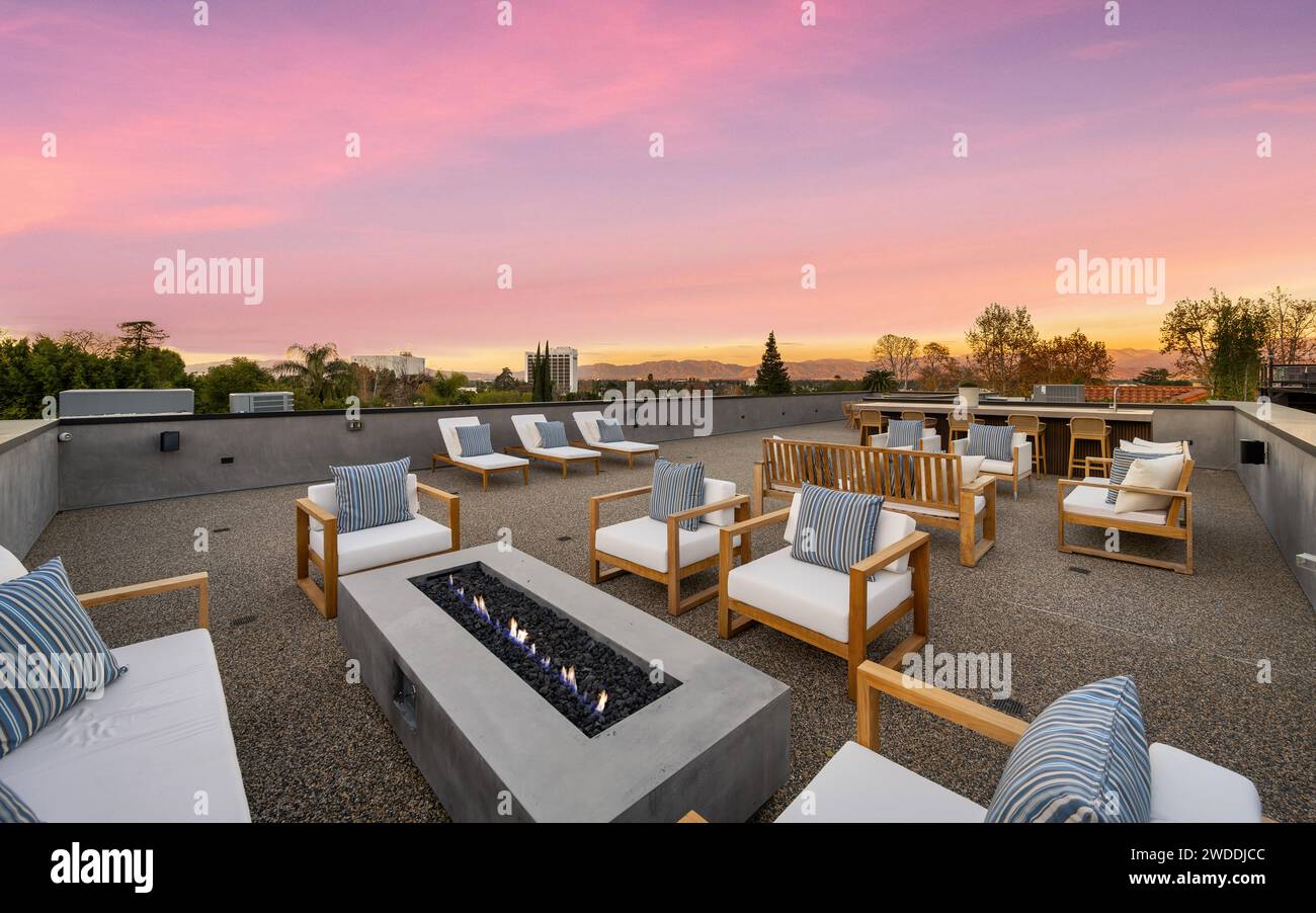 Outdoor patio with seating, tables, and chairs surrounding a cozy fire