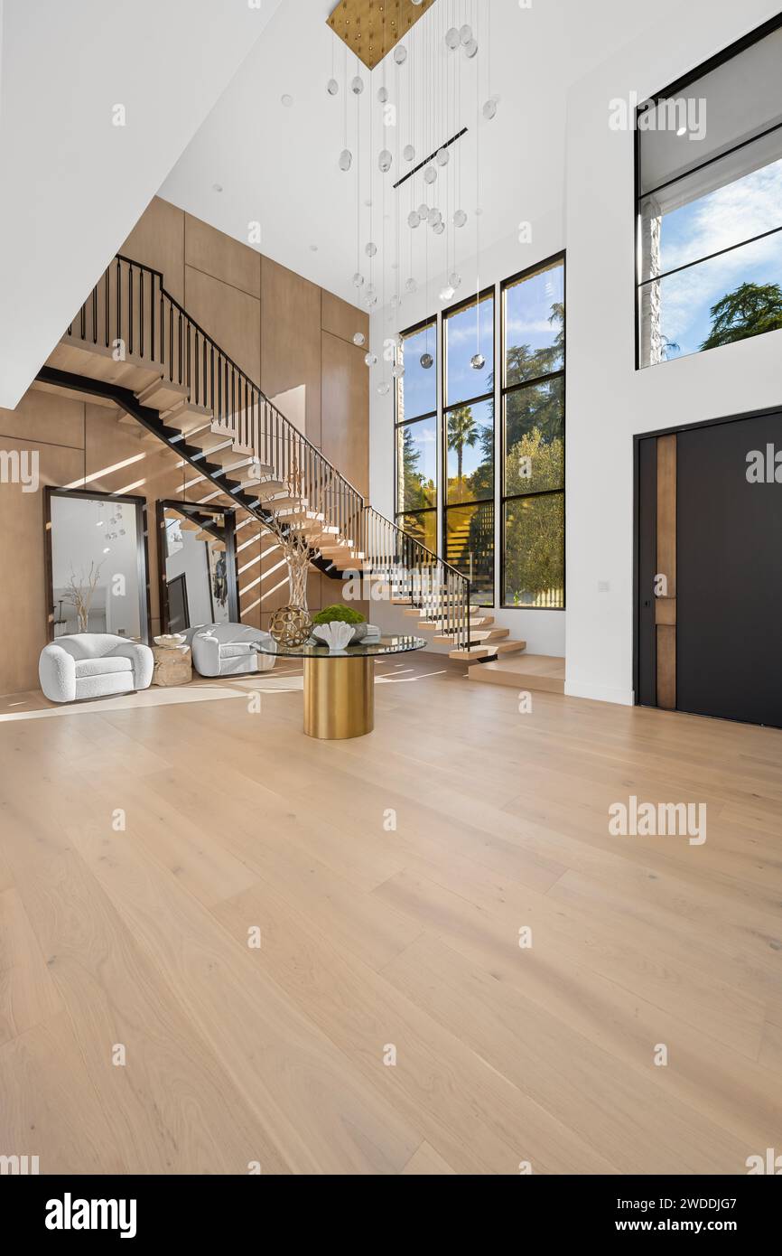 Empty living room with hardwood floors, staircase, and wooden walls Stock Photo