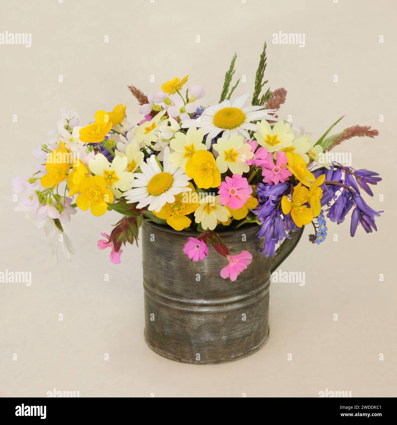Spring Beltane wildflowers and grasses in an old metal vase on hemp ...