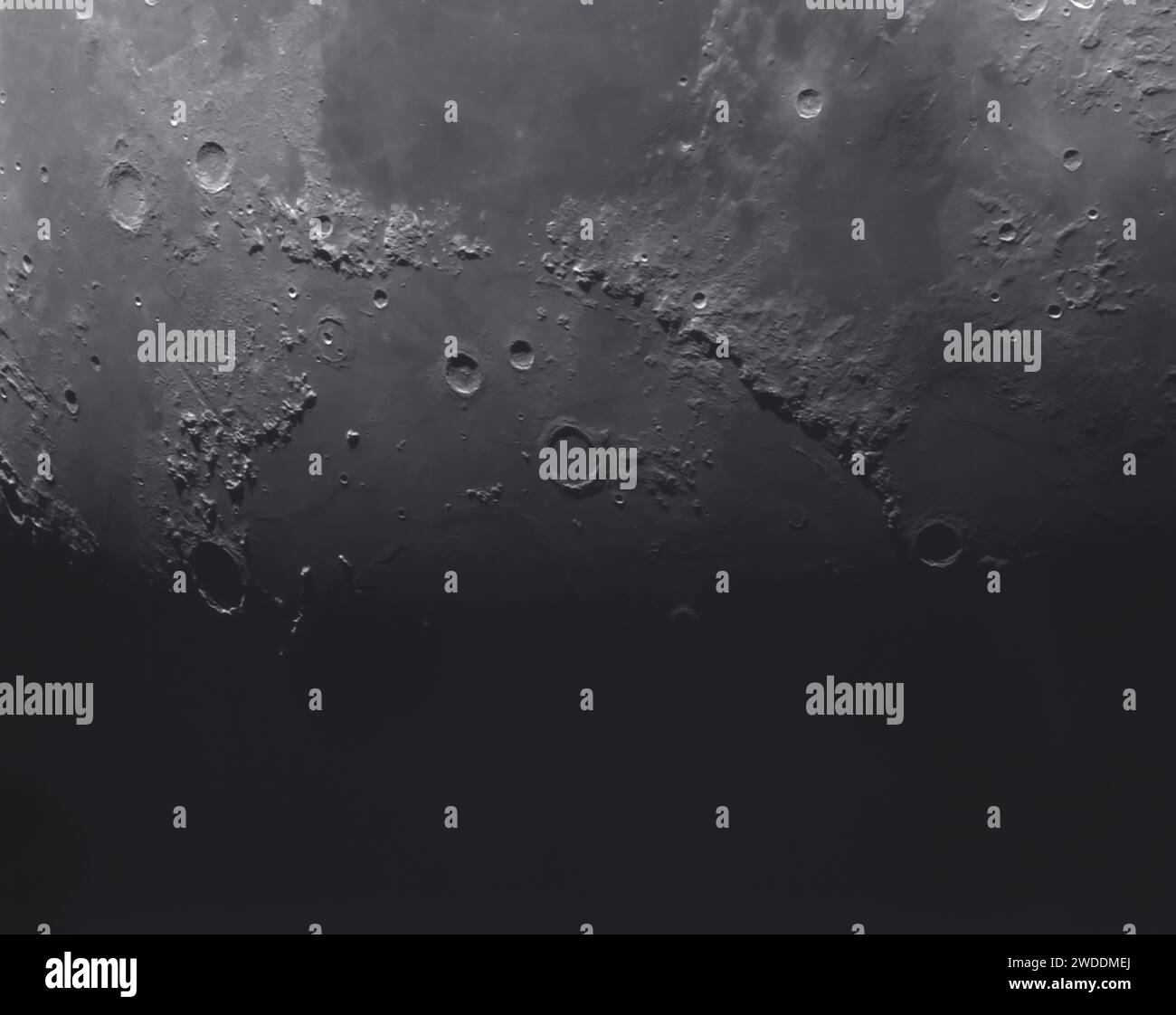 The Mare Imbrium partially in deep shadow, Apennine mountains on the Moon (centre right), and Lunar Alp mountains (centre left) ending in the crater Plato (centre left in deep shadow). Stock Photo