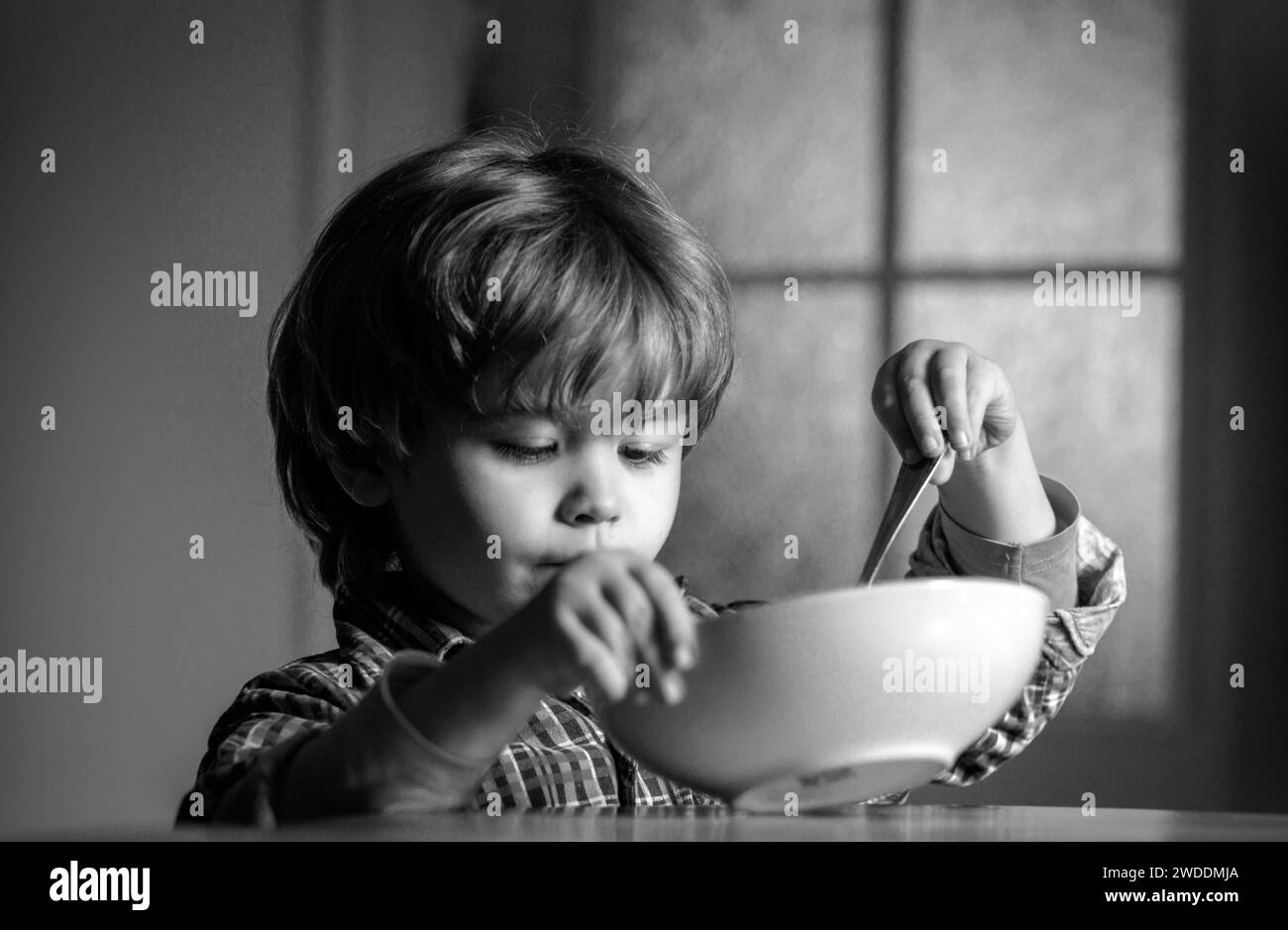 Kid eating. Little boy having breakfast in the kitchen. Cute child