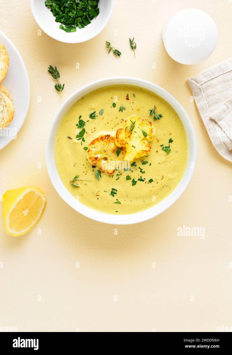 Cauliflower cheese soup in bowl over light background. Vegetarian or healthy diet food concept. Top view, flat lay Stock Photo