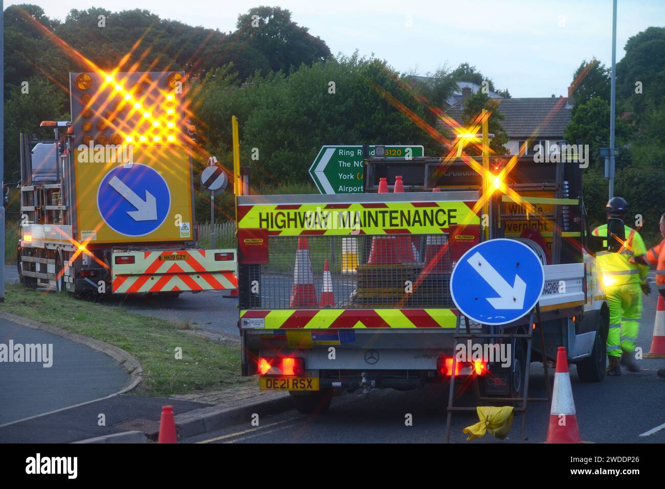 traffic passing flashing warning lights on highway maintenance lorry