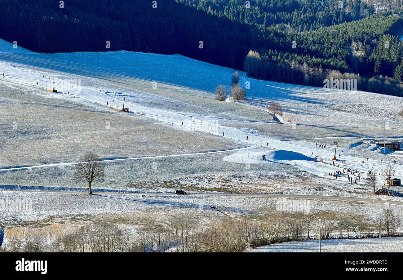 Bernau, Germany. 20th Jan, 2024. Winter sports enthusiasts ski in the sunshine on a narrow band of technical snow. Only a few lifts in the Upper Black Forest are in operation at the weekend because it has recently rained off a lot of snow. Credit: Valentin Gensch/dpa/Alamy Live News Stock Photo