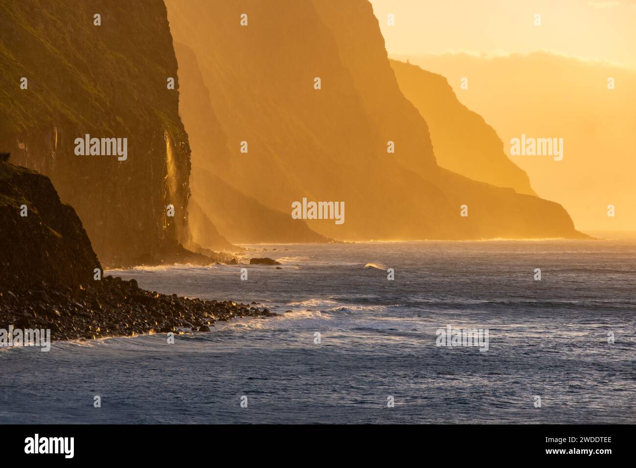 Volcanic rock cliffs Achadas da Cruz in backlit sunlight. Waves of the ...