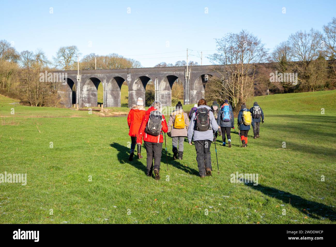 Group of ramblers walking in the Cheshire countryside  approaching the  railway Viaduct  over the river Dean near Wilmslow Cheshire Stock Photo