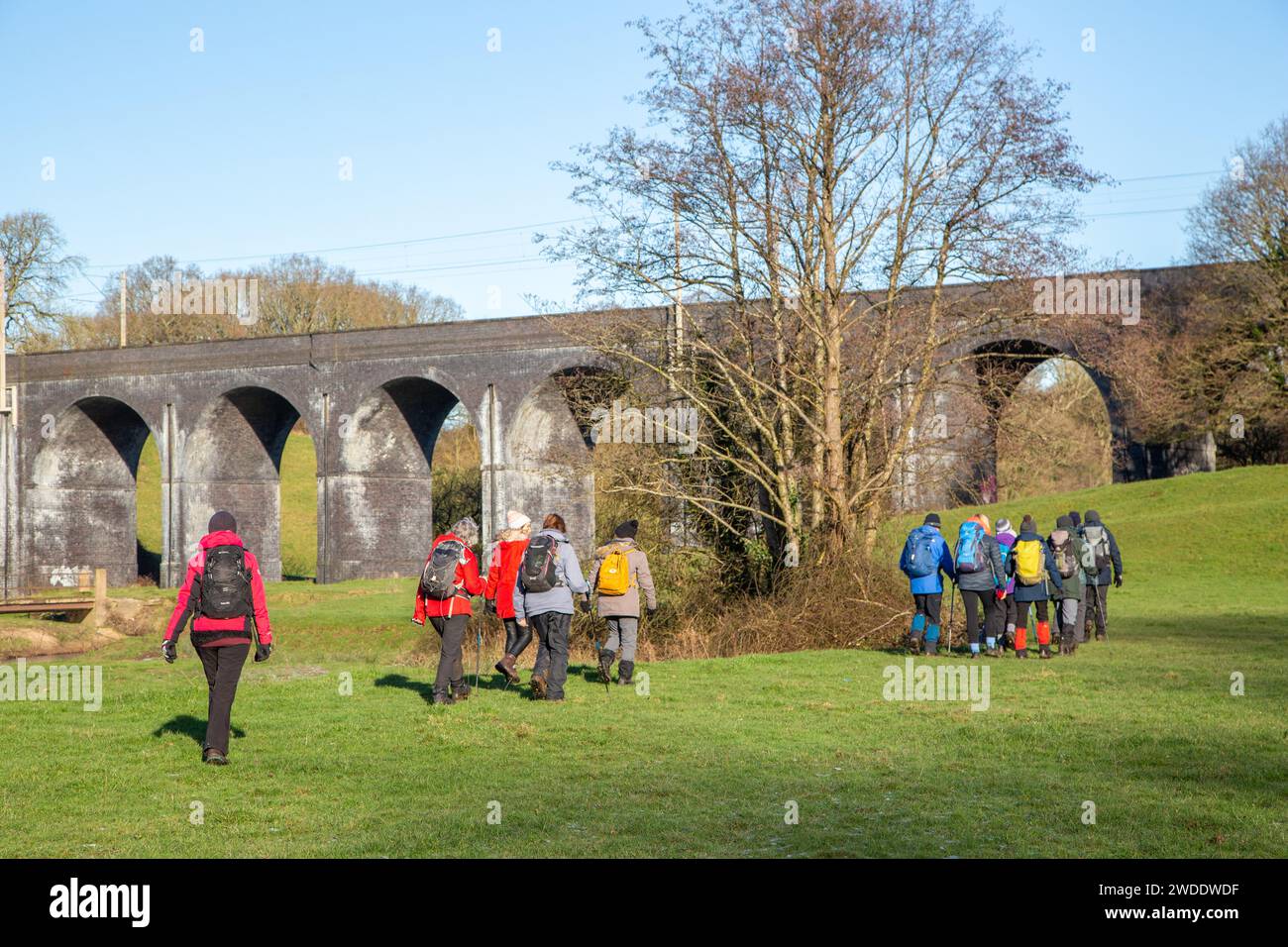 Group of ramblers walking in the Cheshire countryside  approaching the  railway Viaduct  over the river Dean near Wilmslow Cheshire Stock Photo