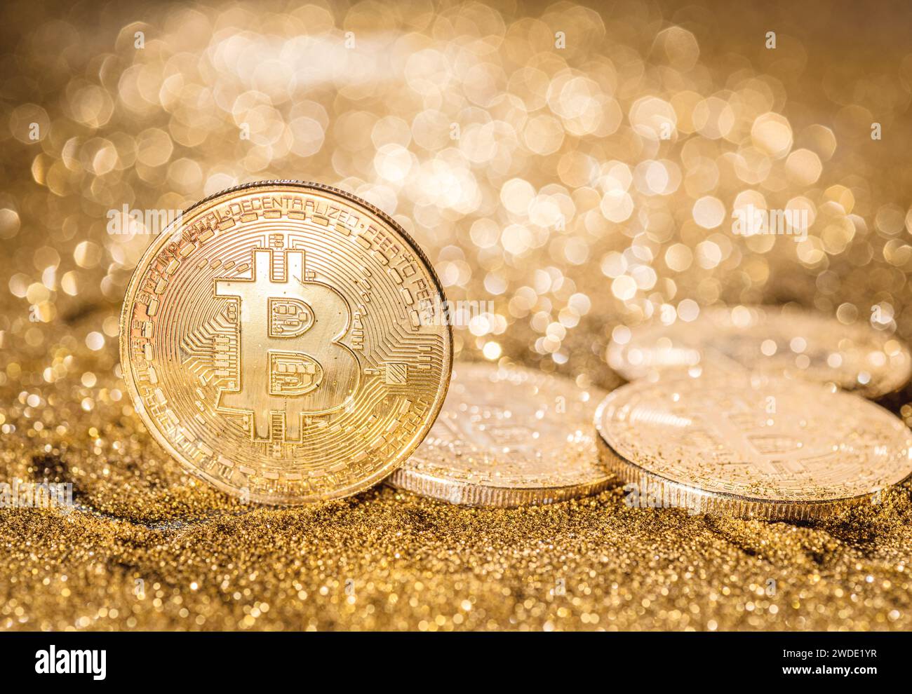 Gold bitcoin coins at the blazing gold background. Conceptual picture of digital money. Stock Photo