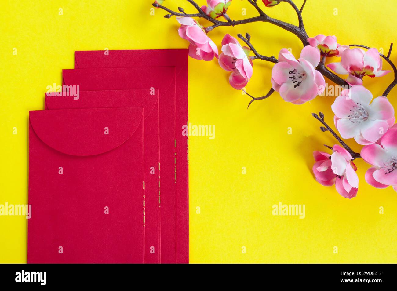 Top view of Chinese New Year red packet and cherry blossom decoration with customizable space for text or wishes. Chinese New Year celebration concept Stock Photo