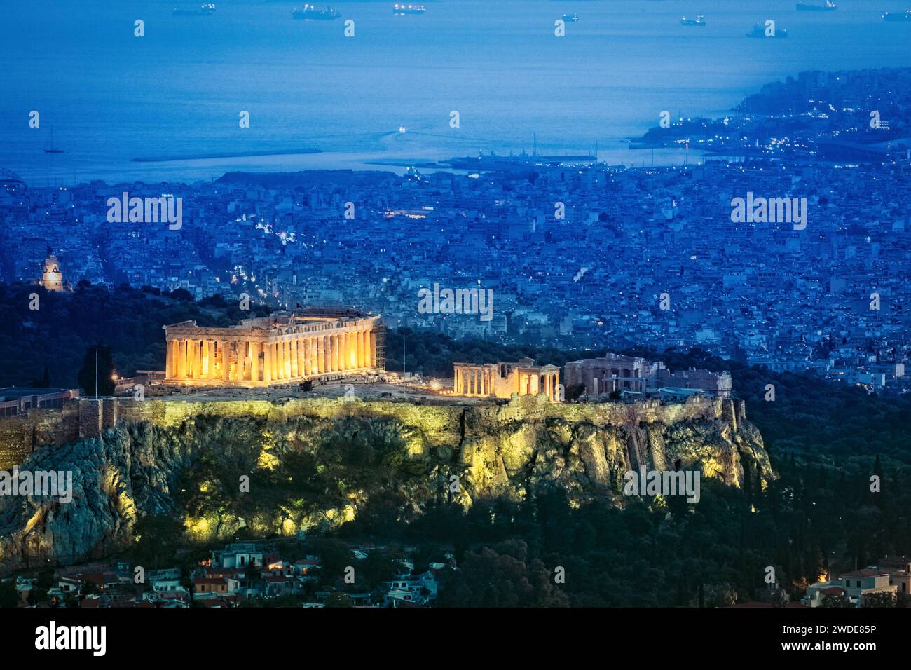 The ruins at the Acropolis light up at dusk in Athens, Greece. Stock Photo
