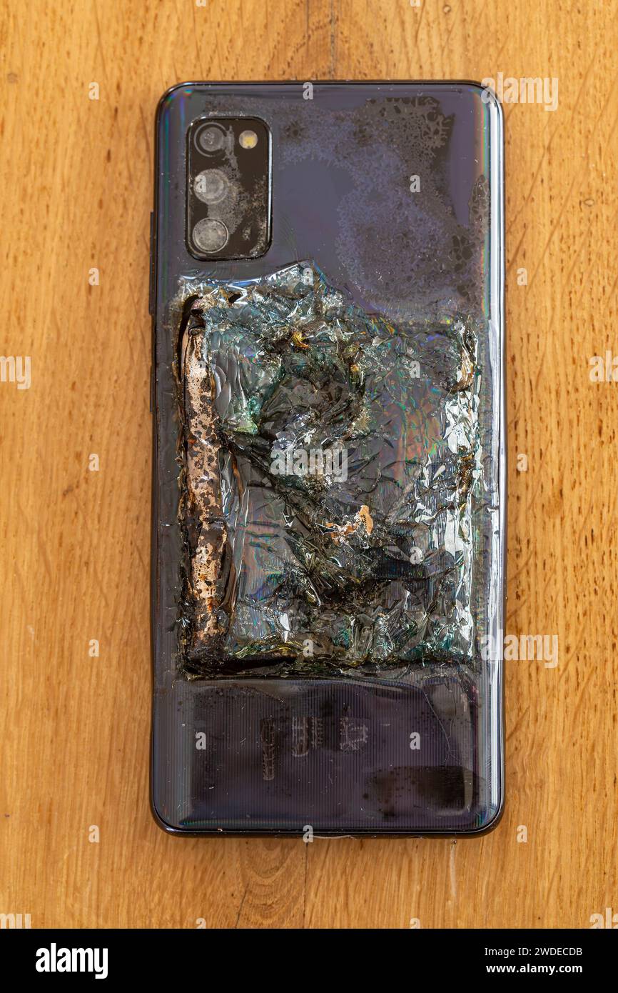 Backside of a destroyed Smartphone. Mobile phone battery exploded Stock