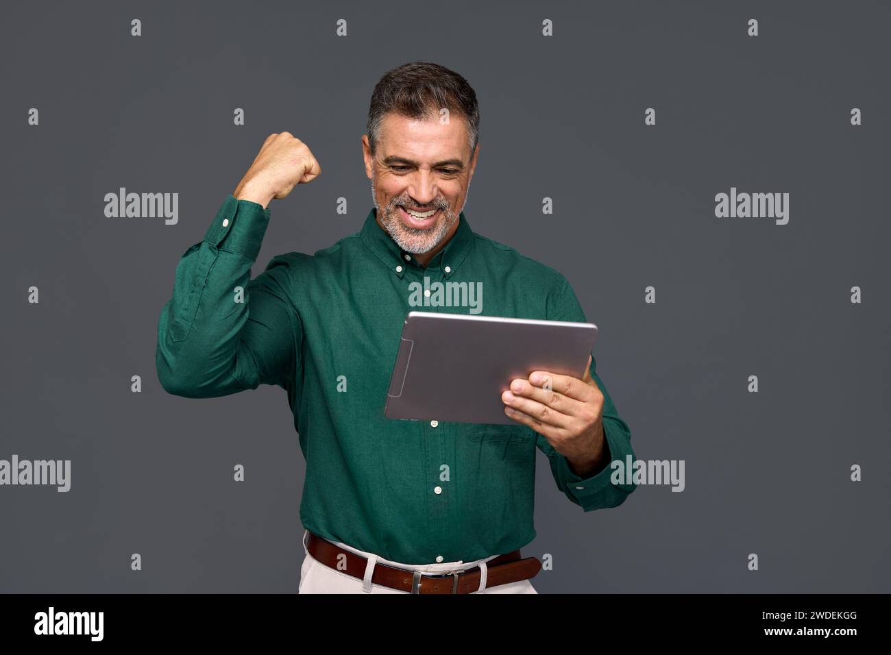 Happy older business man investor looking at digital tablet winning online. Stock Photo