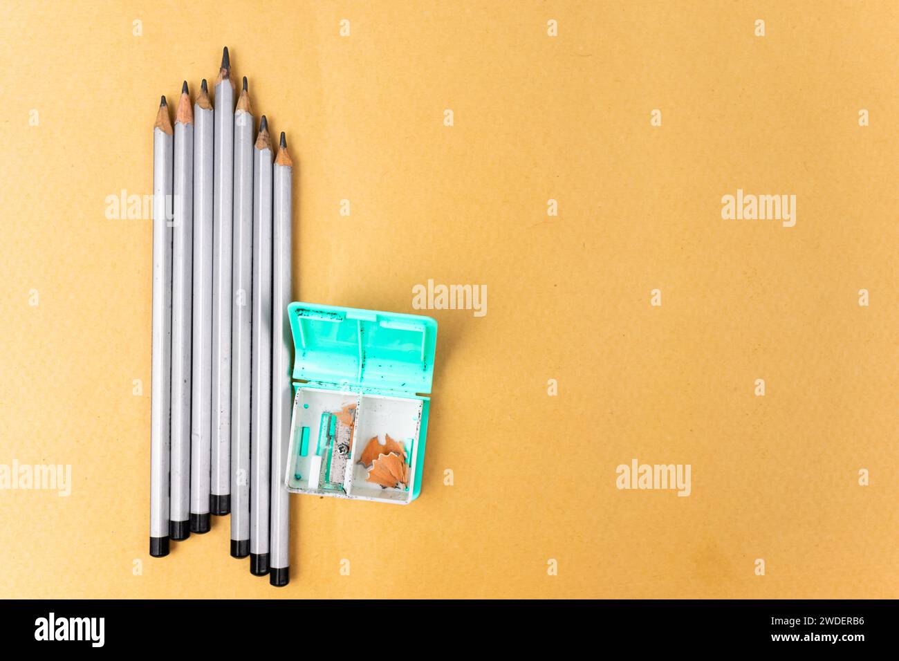 Several pencils and a sharpener on a yellow background. Copy space Stock Photo