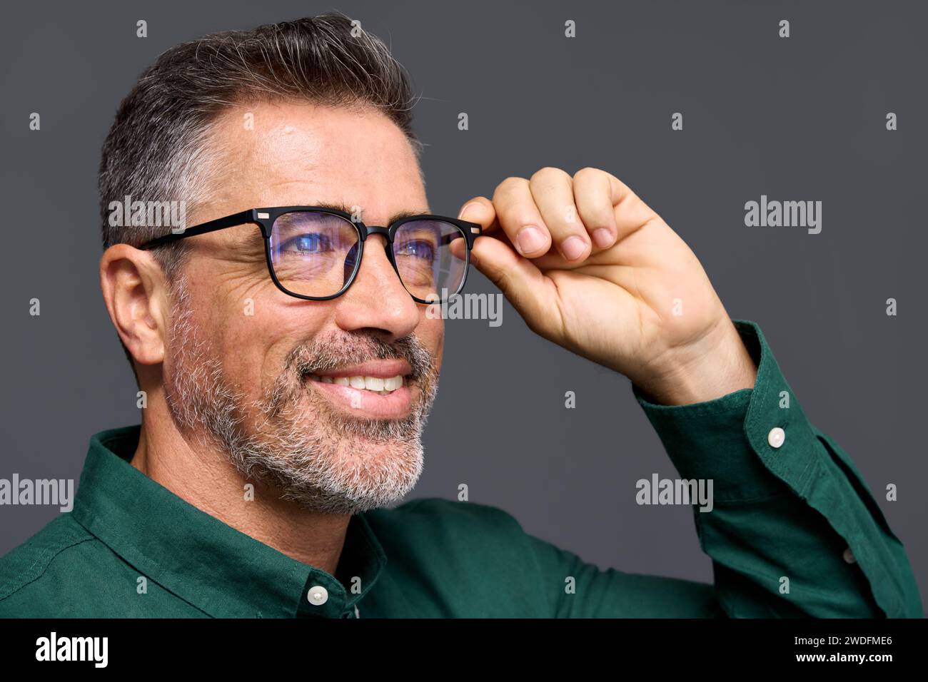 Smiling mature business man wearing stylish eyeglasses isolated on grey. Stock Photo