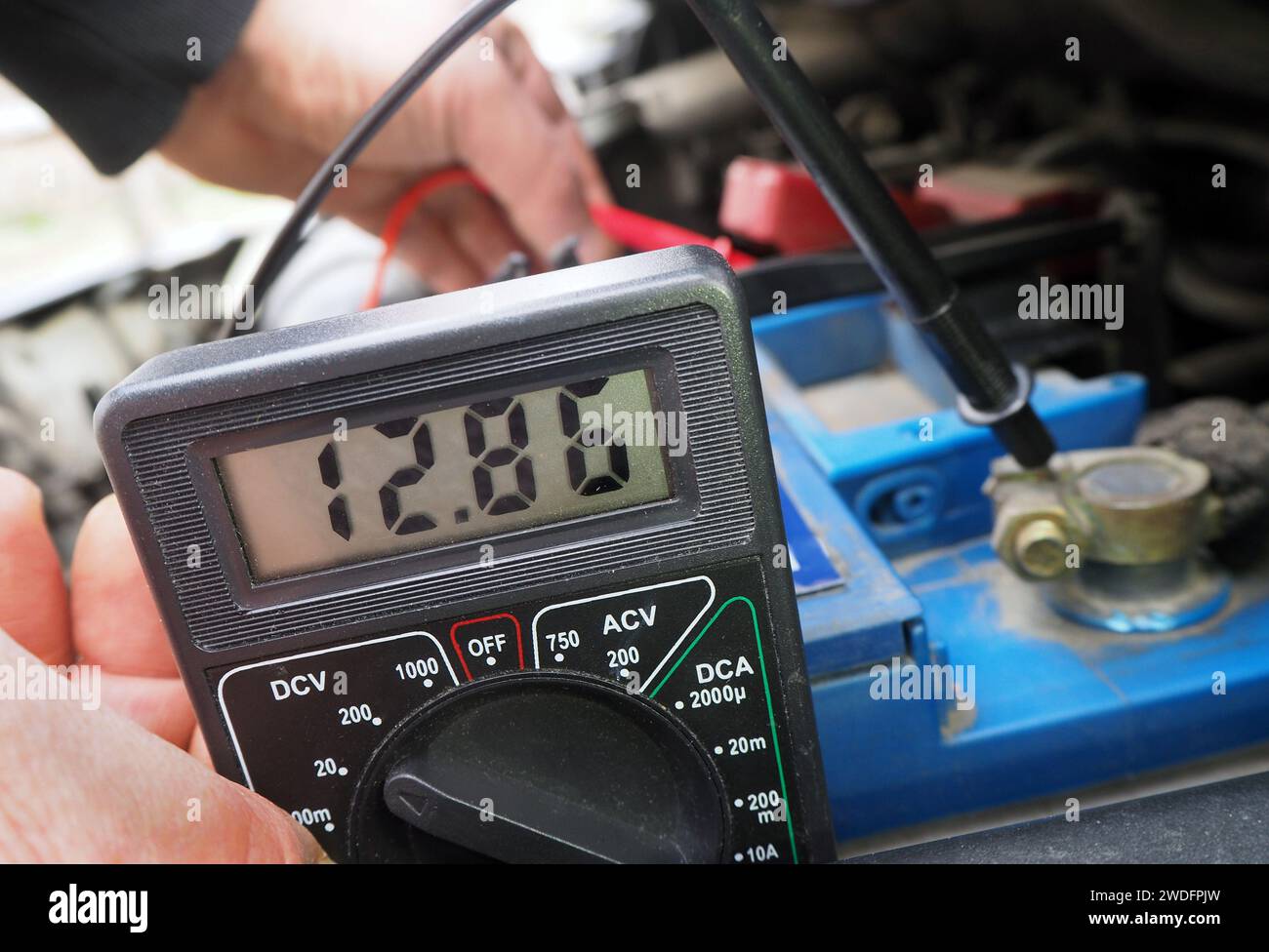 Checking vehicle battery voltage.Battery voltage measurement by using a multimeter. Vehicle accumulator voltage test. Stock Photo