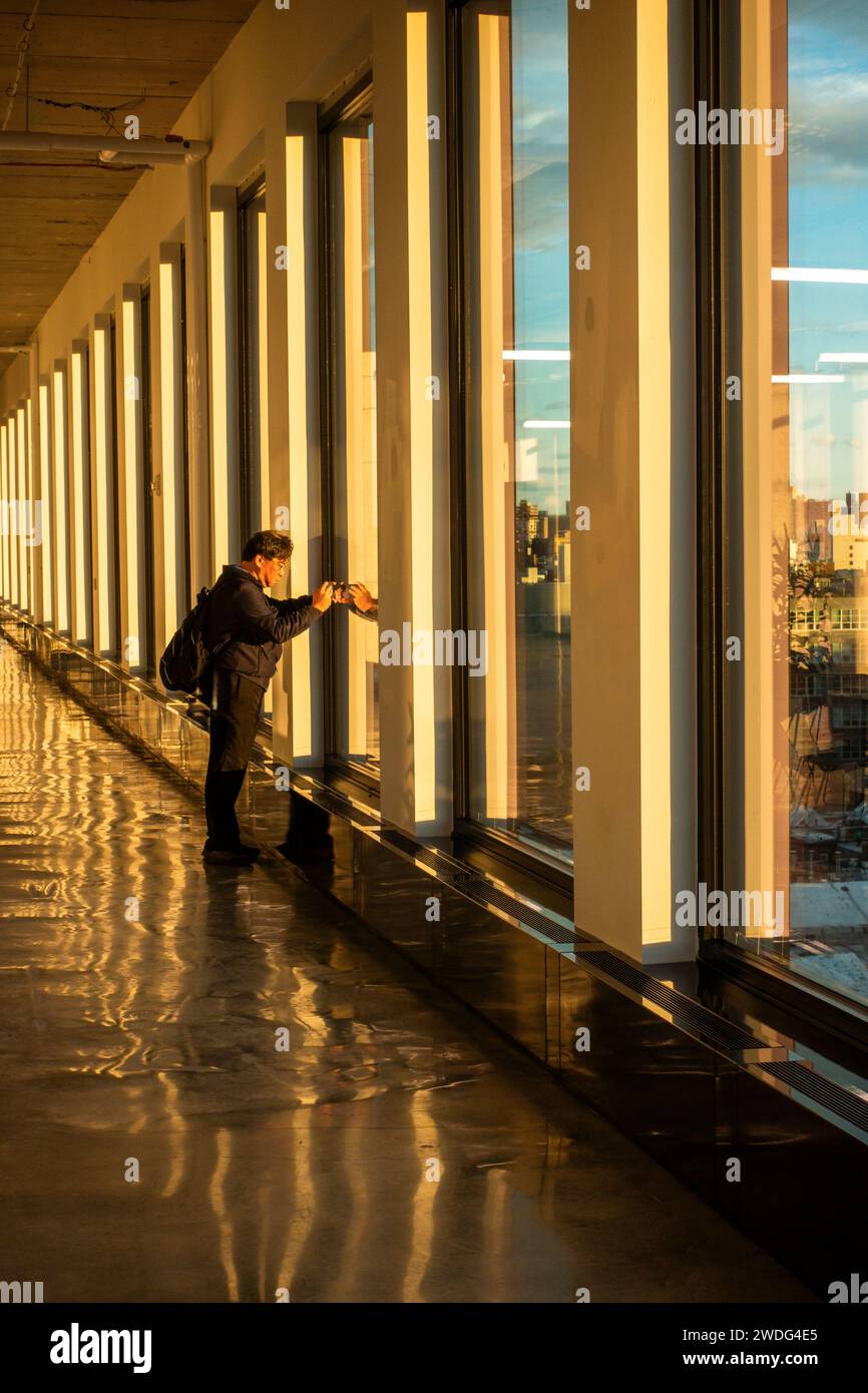 man taking photo from the top of 25 Kent Avenue in Williamsburg Brooklyn NYC Stock Photo