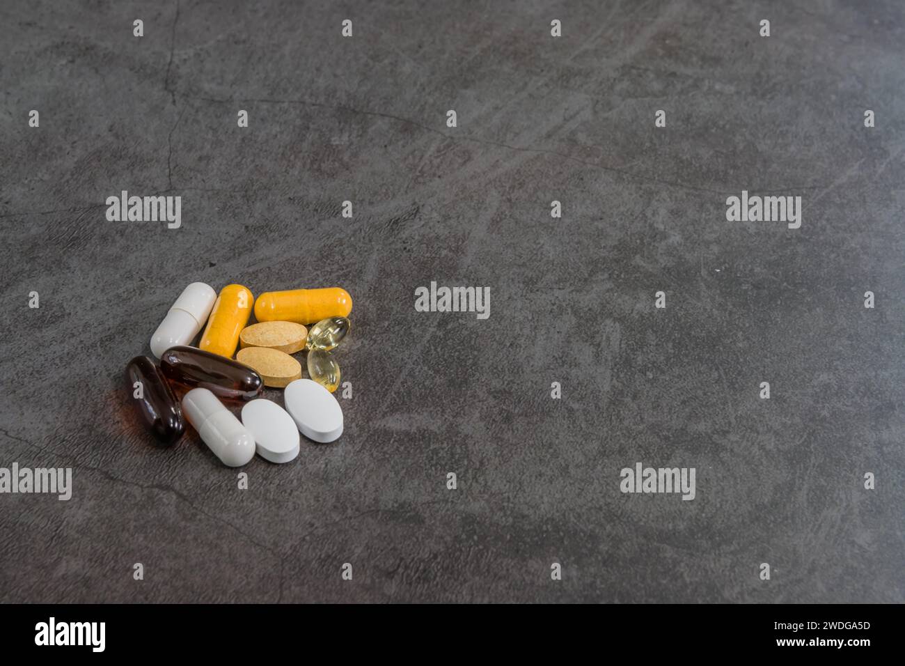 Collection of various vitamins in both pills and gelcap on black textured background Stock Photo