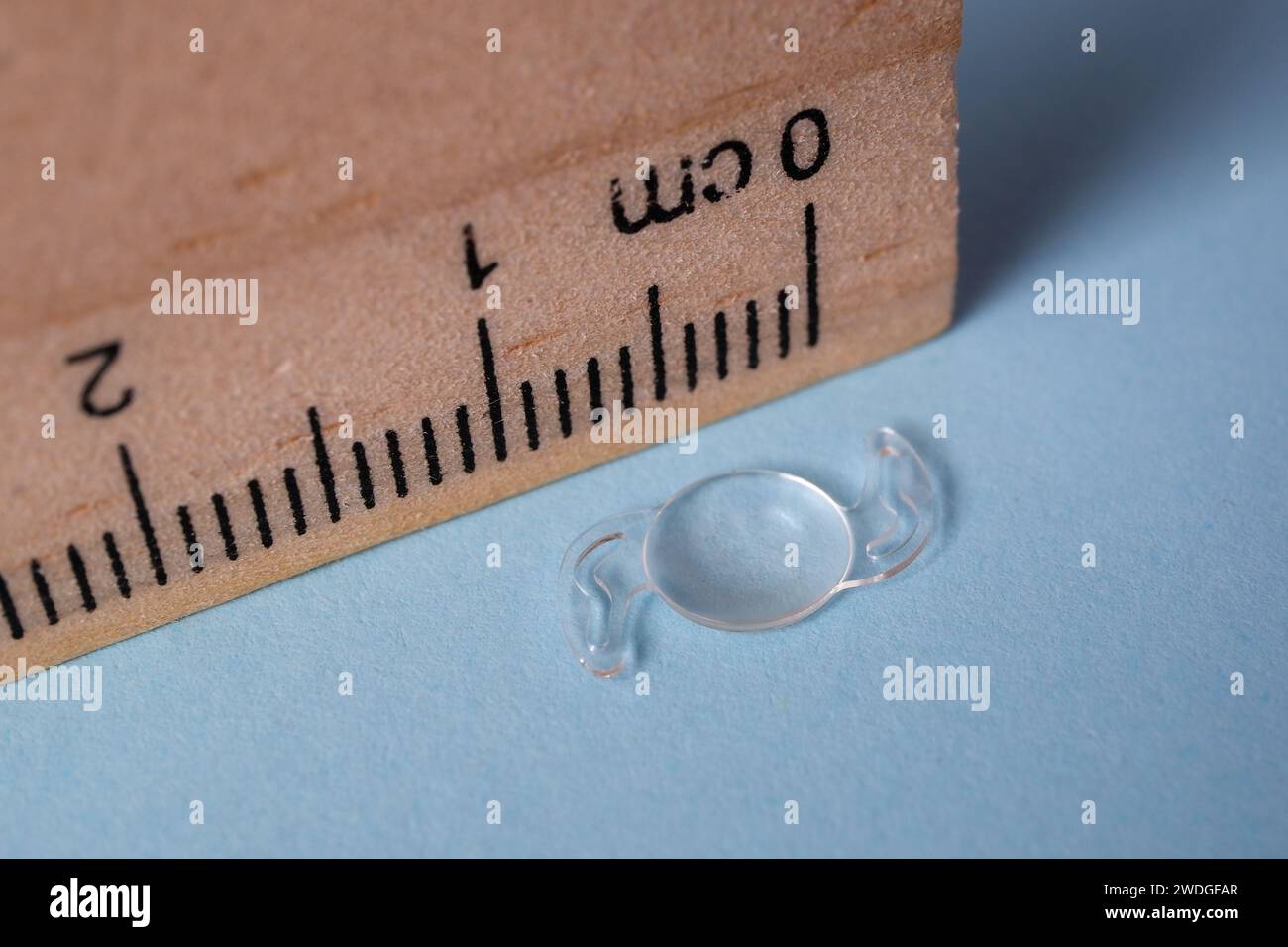 photo of foldable itraocular lens IOL for treating cataract beside wooden ruler Stock Photo