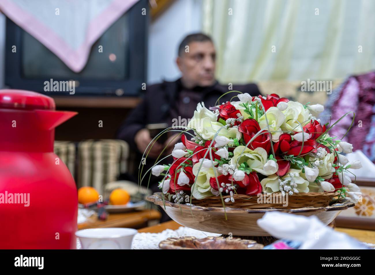 Coffee pot with guests in the background  and roses Stock Photo