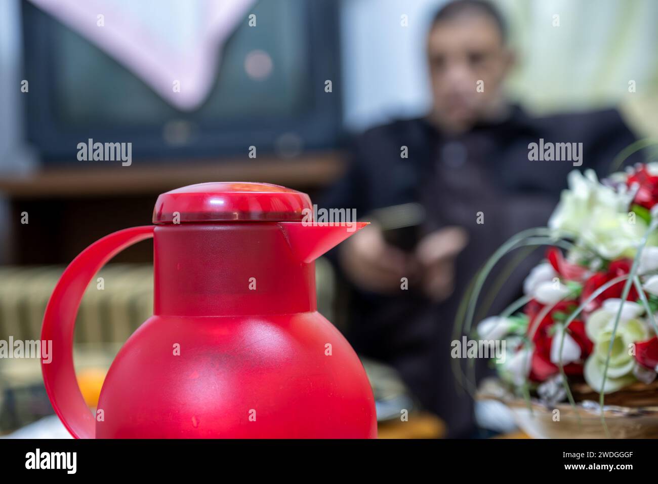 Coffee pot with guests in the background  and roses Stock Photo