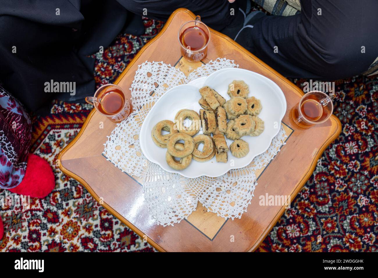 Family gathering around eid sweets with tea cups Stock Photo