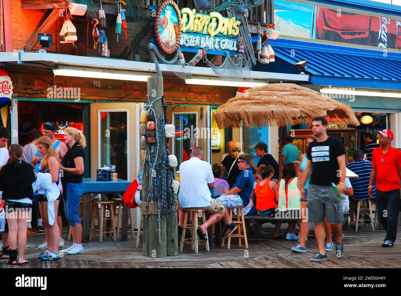 People gather around the bars and cafes along the boardwalk of Myrtle Beach, South Carolina on a summer vacation evening Stock Photo