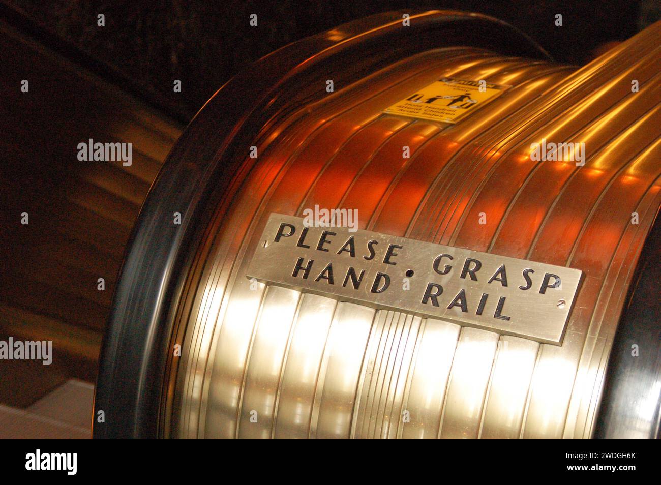A sign on the escalators, in a vintage art deco style,  in a New York City building requests guests to grab the hand r Stock Photo