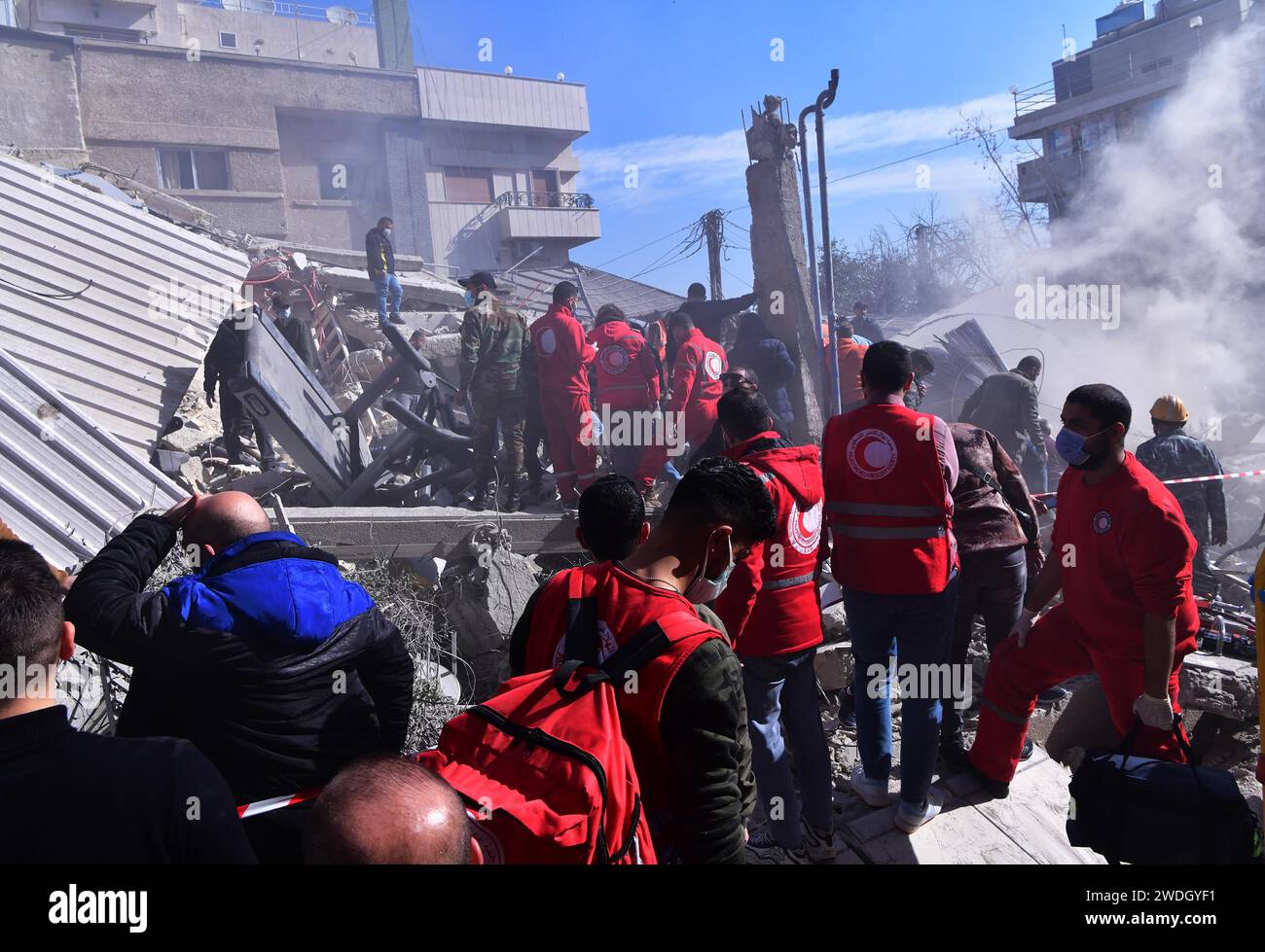 Damascus, Syria. 20th Jan, 2024. Rescuers work at the site of a