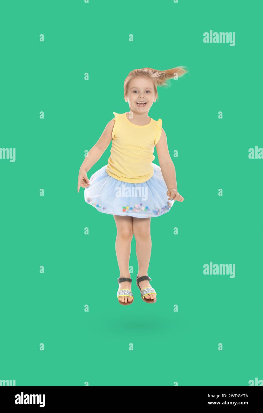 Happy cute girl jumping on turquoise background Stock Photo - Alamy