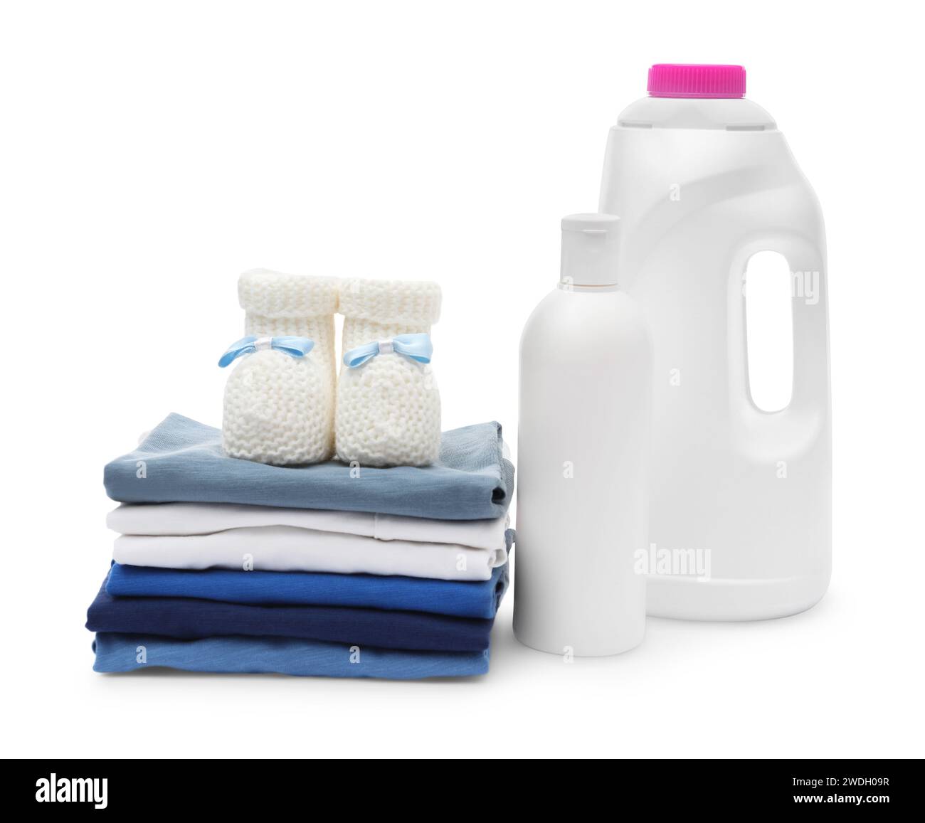 Laundry detergents, stack of baby clothes and small booties isolated on