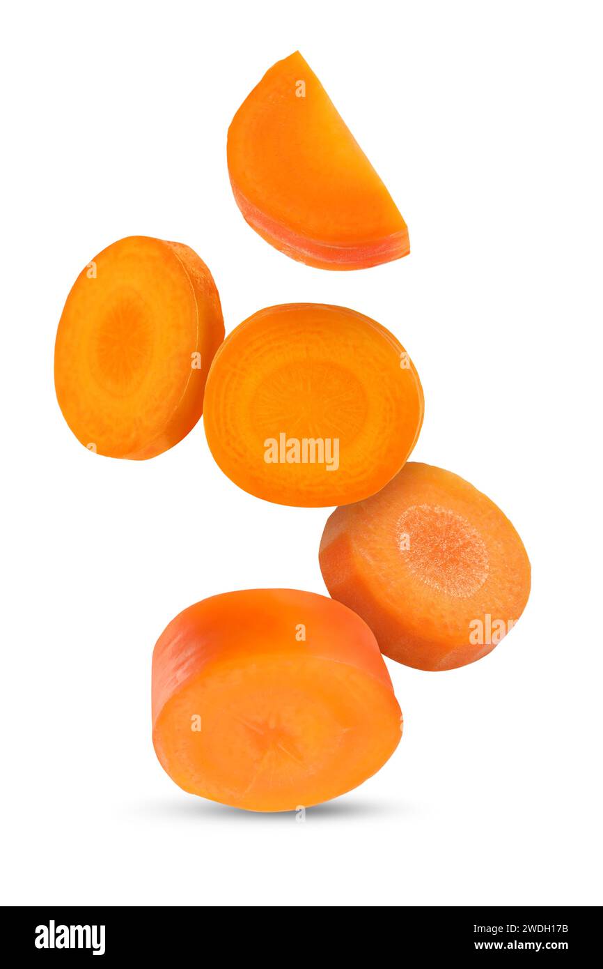 Fresh carrot slices falling on white background Stock Photo