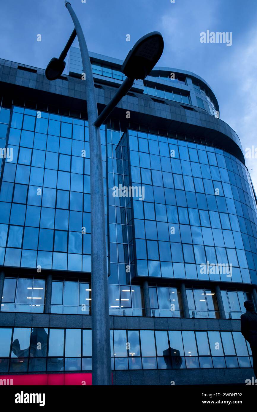 office building with a glass facade and a blue sky Stock Photo - Alamy