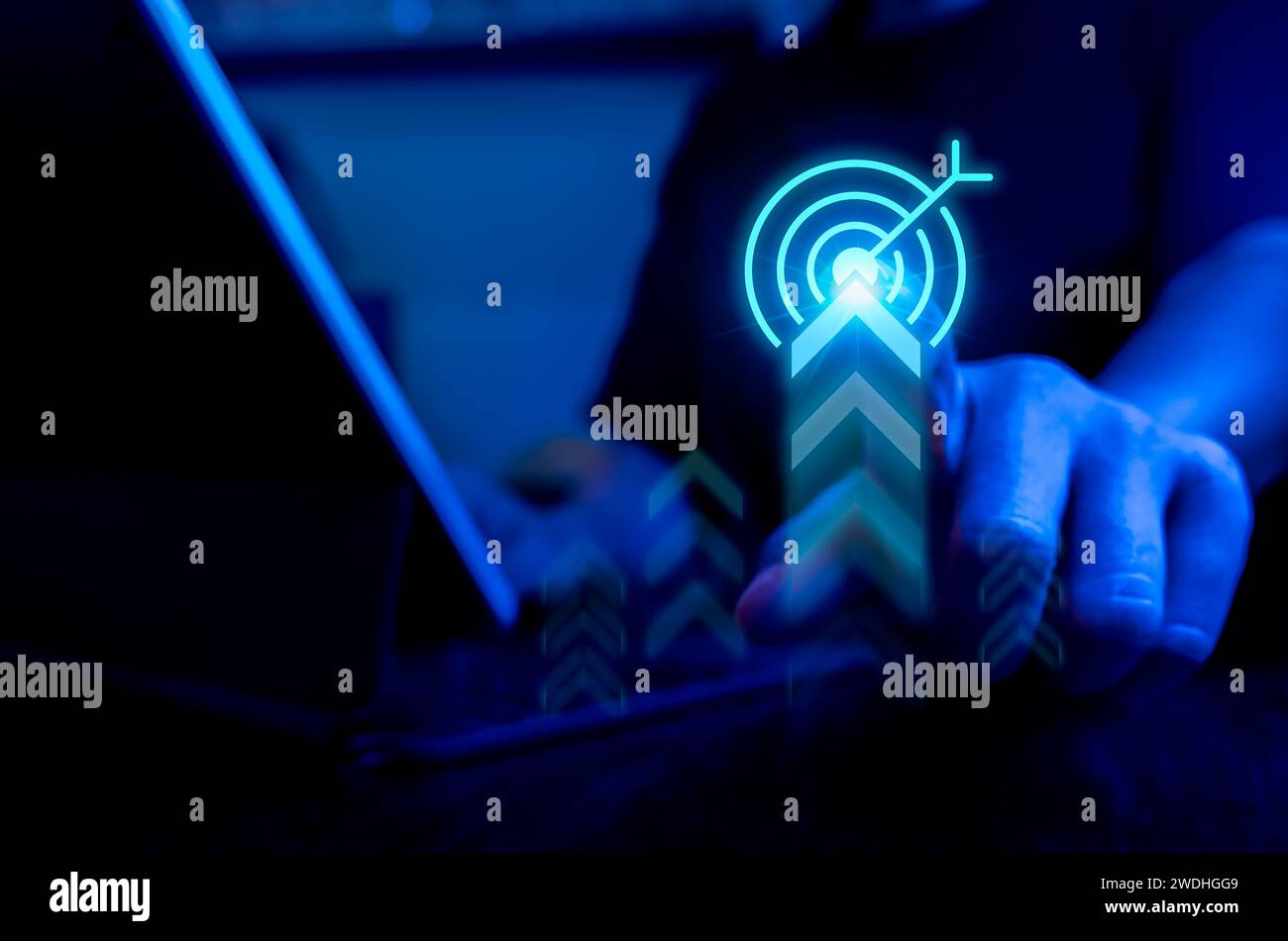 Businessman pressing on big target icon with rising arrow while working with laptop computer, blue tone. Business strategy, action plan and future inn Stock Photo