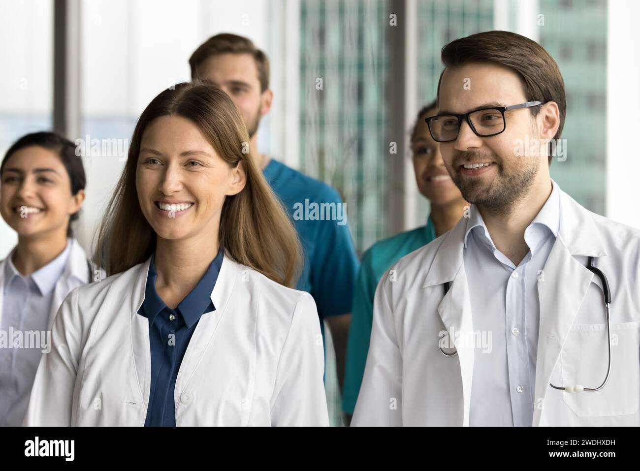 Cheerful young practitioners standing together for shooting, looking away Stock Photo