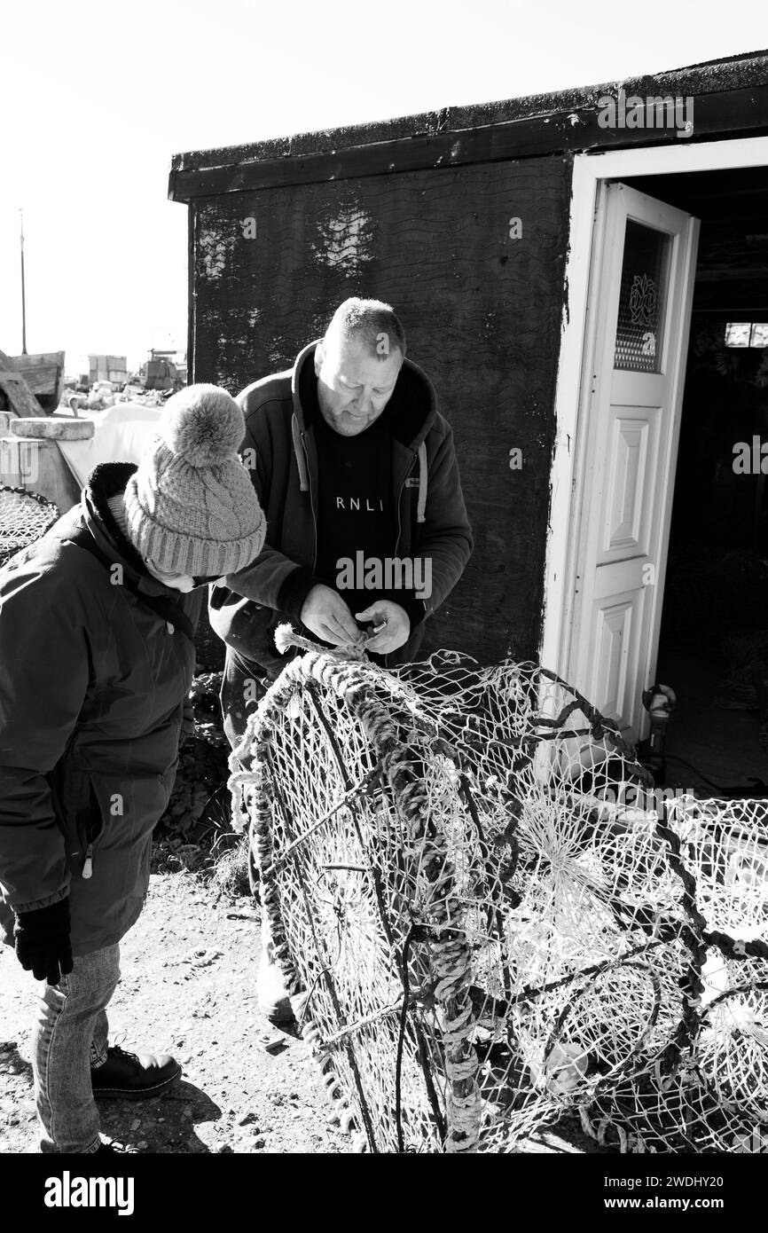 Hastings fisherman mending cuttlefish pots on the Old Town Stade at Rock-a-Nore, East Sussex, UK Stock Photo