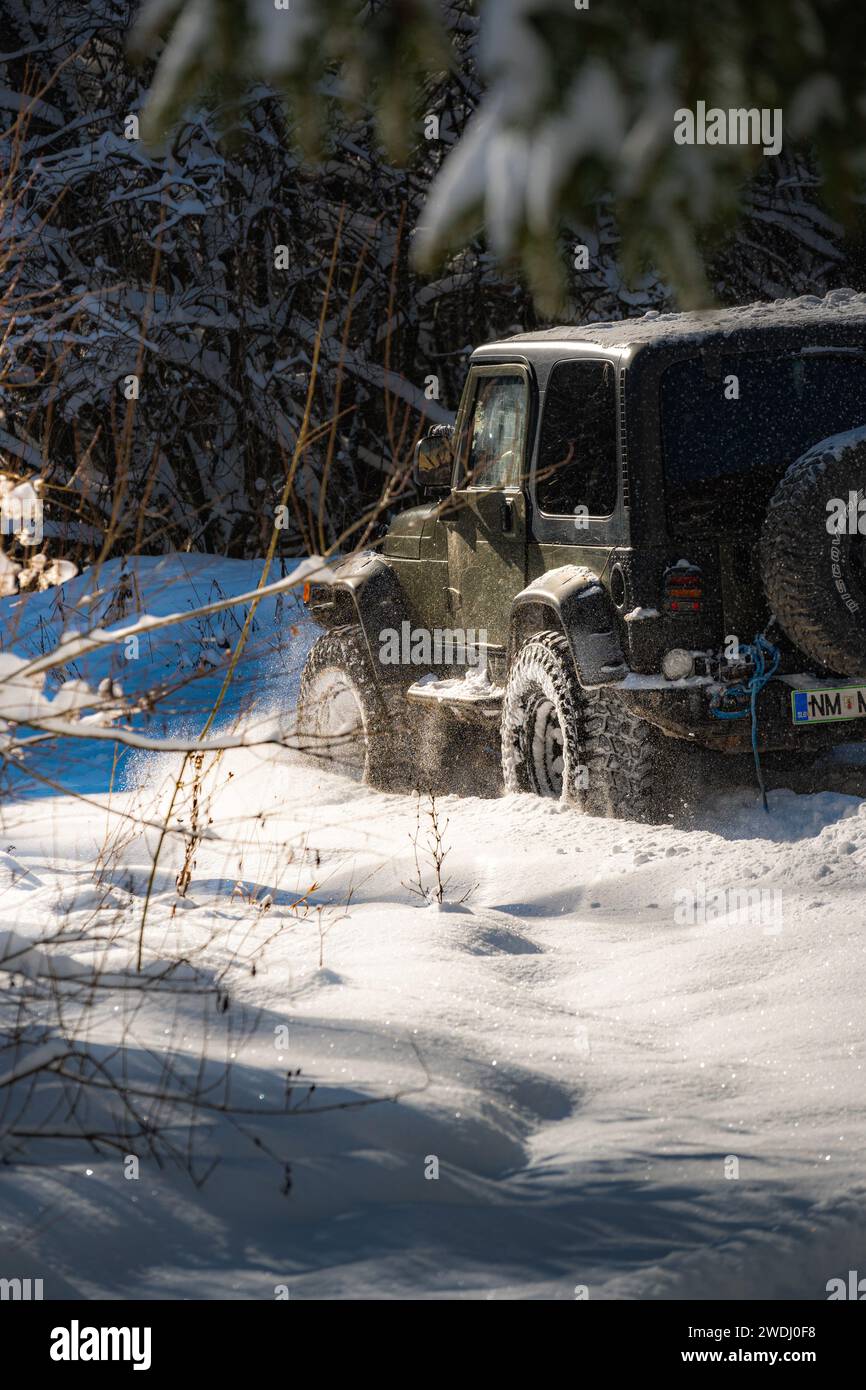 Offroad vehicle driving in snowy mountain Stock Photo