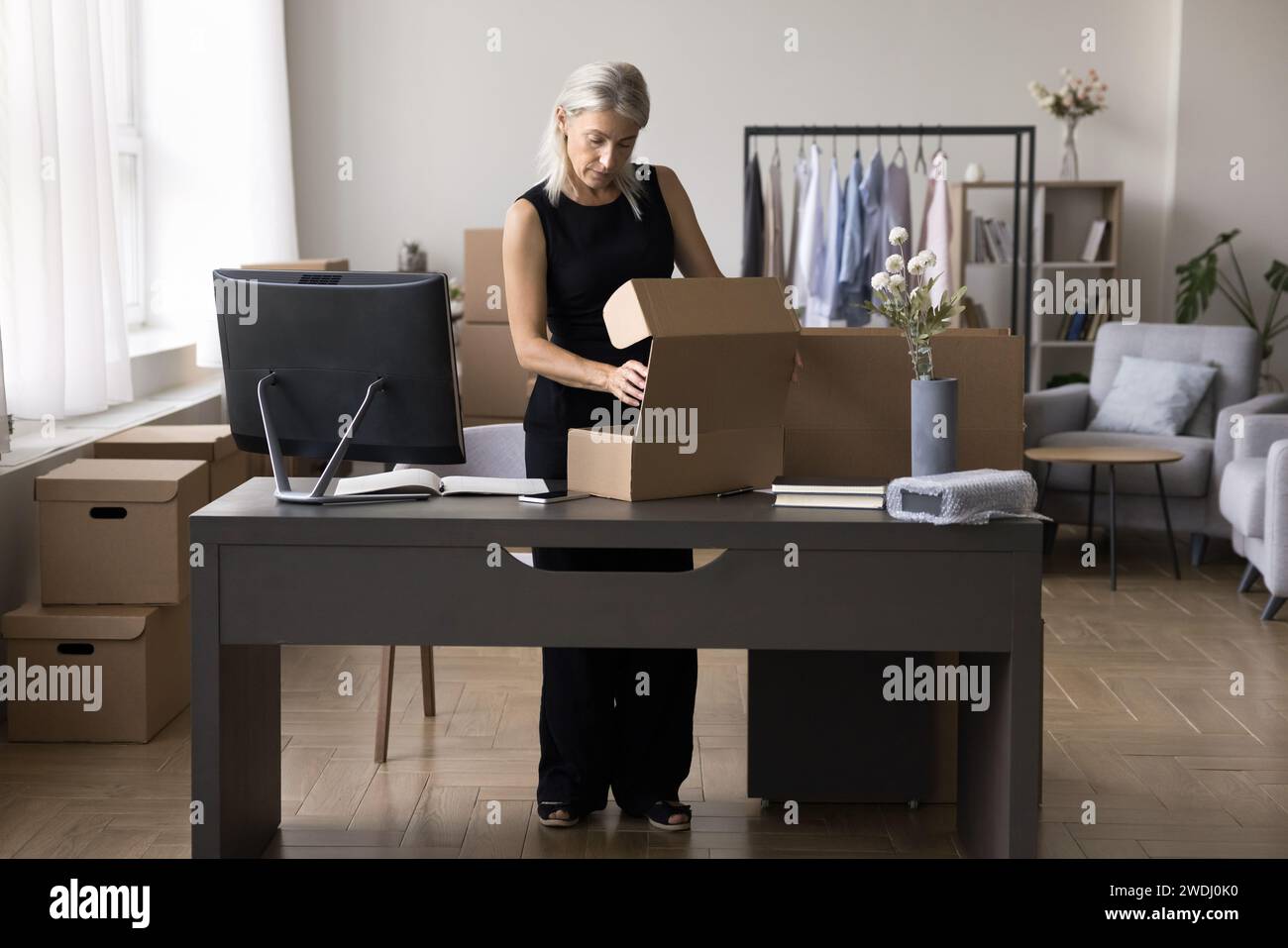 Businesswoman preparing box, ordered goods to client for sending Stock Photo