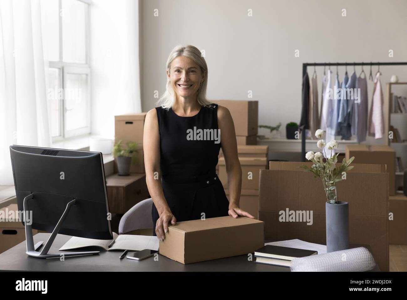 Portrait of happy mature businesswoman posing in warehouse office Stock Photo