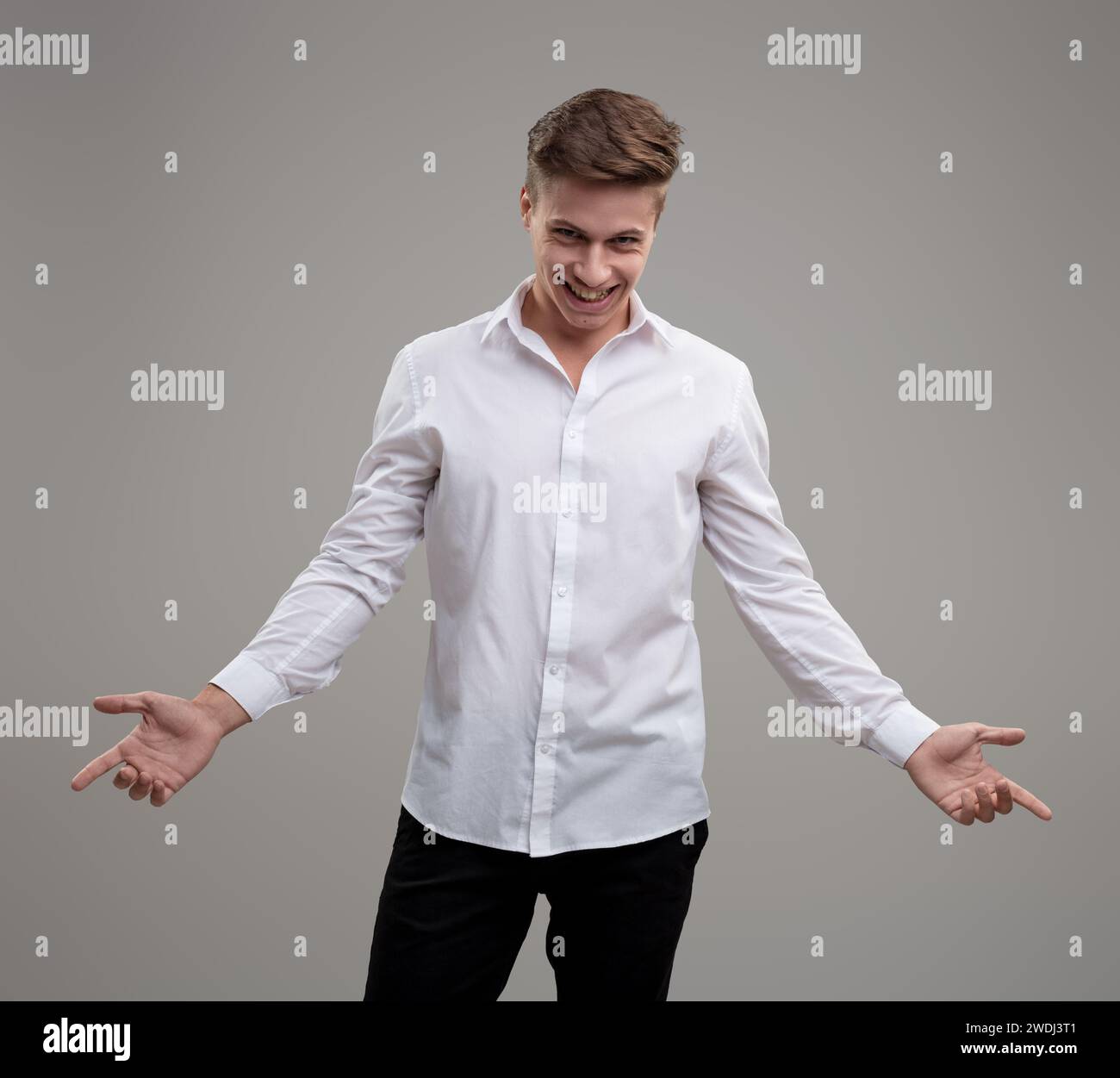 Young man's gesture in white shirt symbolizes openness to new experiences and social connection Stock Photo