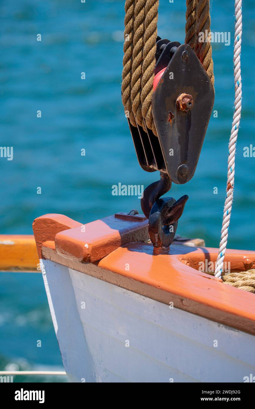 The clinker-built lifeboat Ben Dwyer mounted onboard the historic coal fired, 1902 steam tug Waratah, suspended from a large rope pully Stock Photo