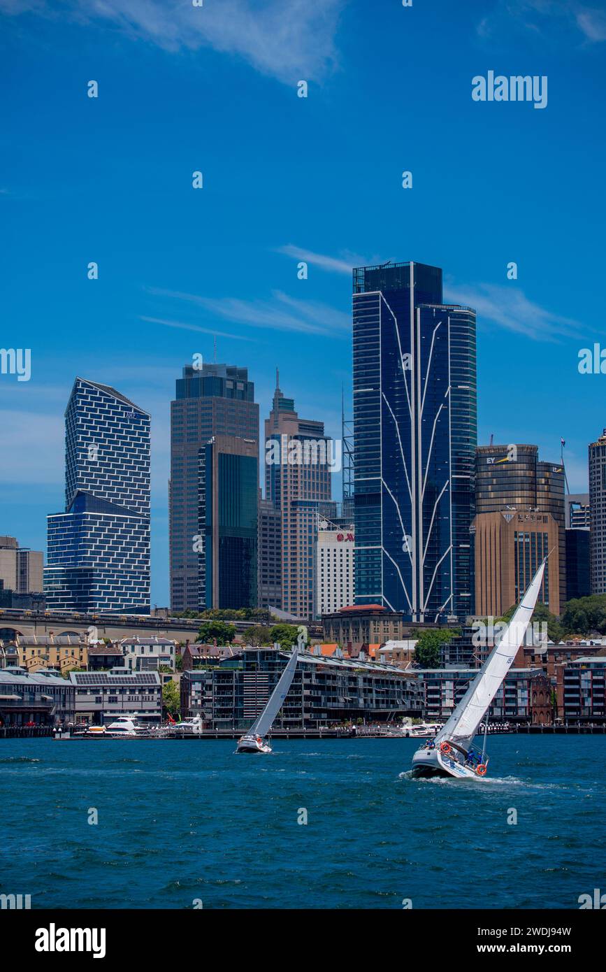 With central Sydney City in the background, yachts sail (tack) upwind into a strong 'nor-easter' or north easterly breeze on Sydney Harbour, Australia Stock Photo