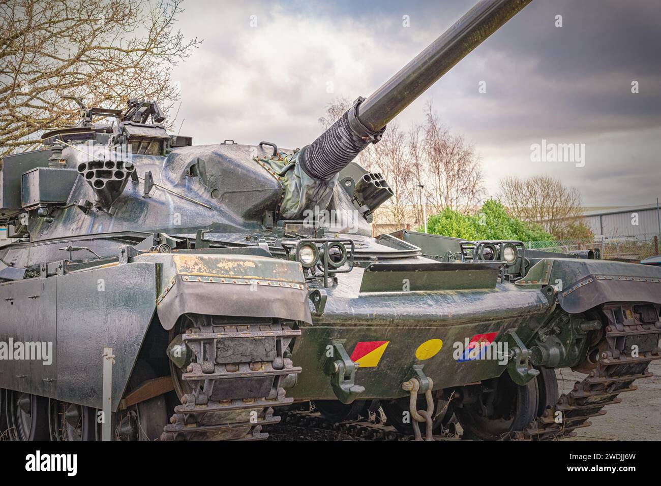 A Chieftain Main Battle Tank on display at a an air museum. The 120mm gun is elevated and there is a sky with cloud above. Stock Photo