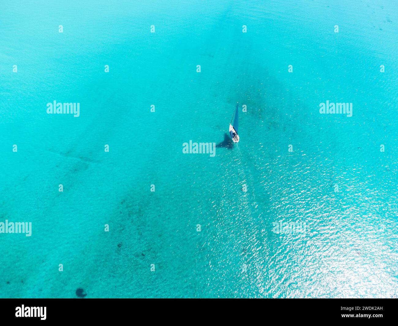 Aerial view of a boat sailing on the turquoise water in Sardinia, Italy ...
