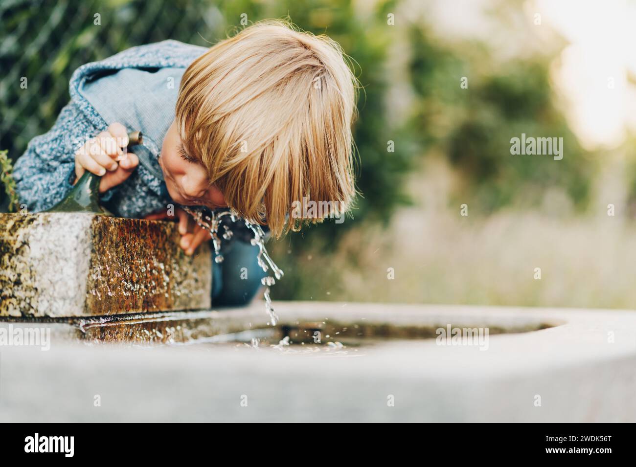 Little boy drinking from a water fountain Stock Photo Alamy