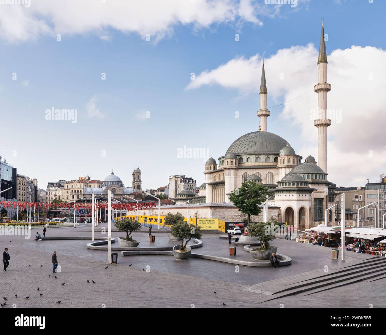 Istanbul, Turkey - May 13, 2023: Street scene in Taksim Square, with Taksim Mosque, Aya Triada Greek Orthodox Church and few walking pedestrians Stock Photo